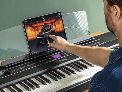 The Yamaha “Smart Pianist” app icon, together with a tablet placed on the music stand of the P-525