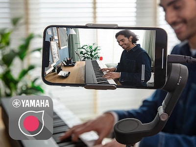 A view of the Yamaha Rec'n'Share app icon and a person taking a smartphone video of them playing