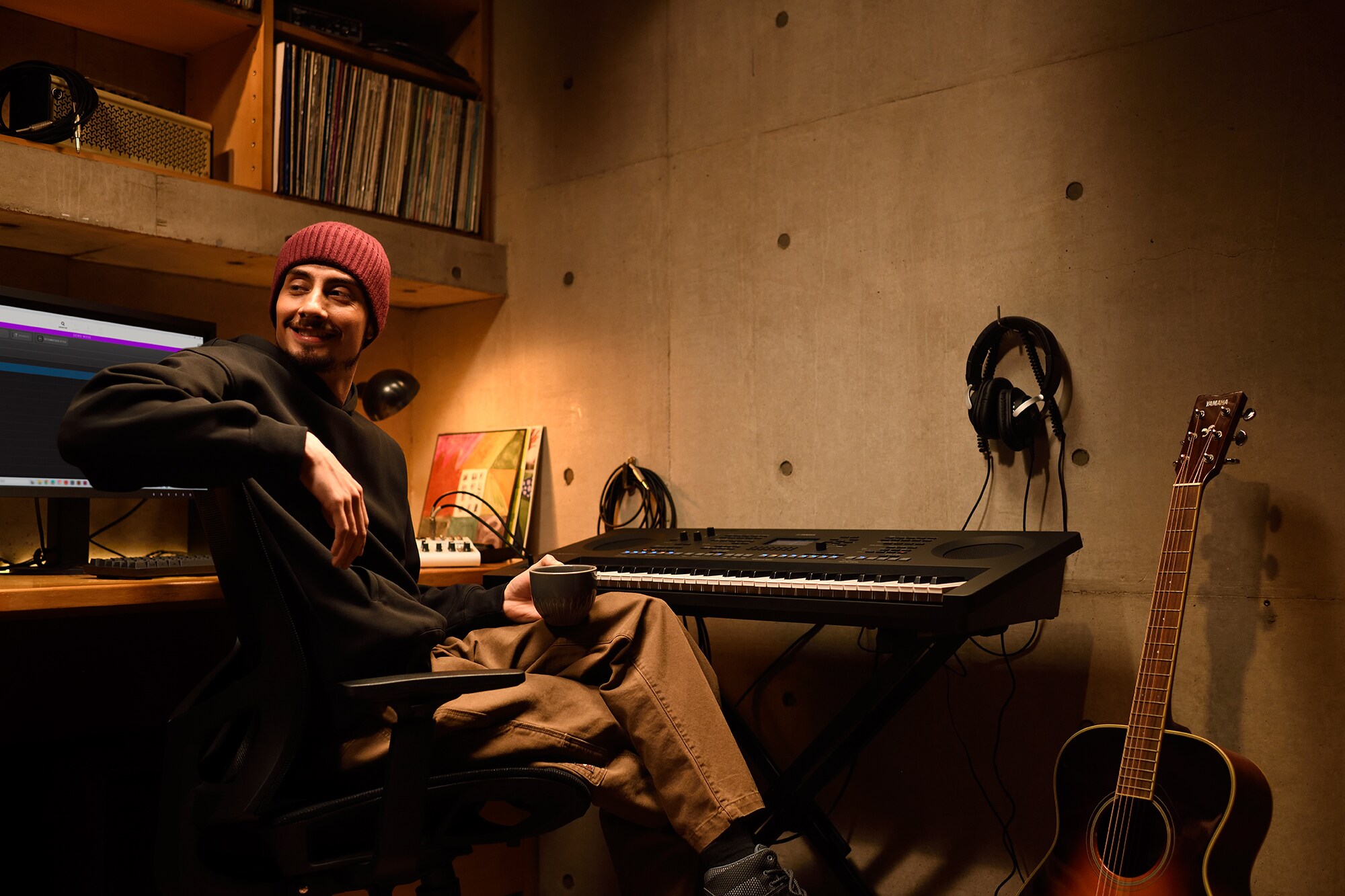 Un espace de création musicale à domicile avec un ordinateur et un clavier, montrant un claviériste travaillant dans son home studio