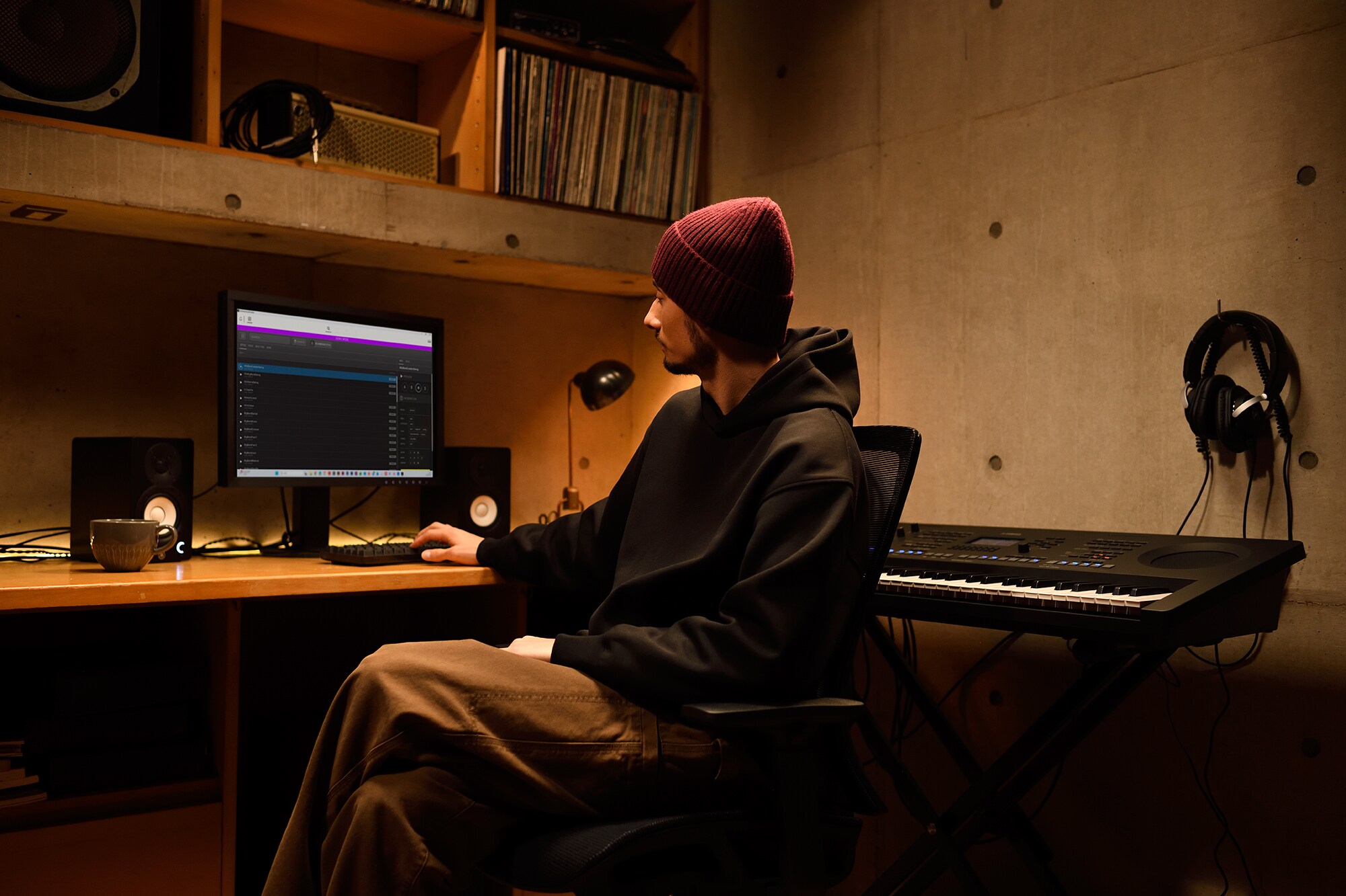 Un espace de création musicale à domicile avec un ordinateur et un clavier, montrant un claviériste travaillant dans son home studio