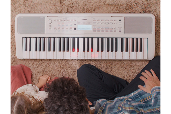Father and daughter watch the keys on the EZ-310 glow.
