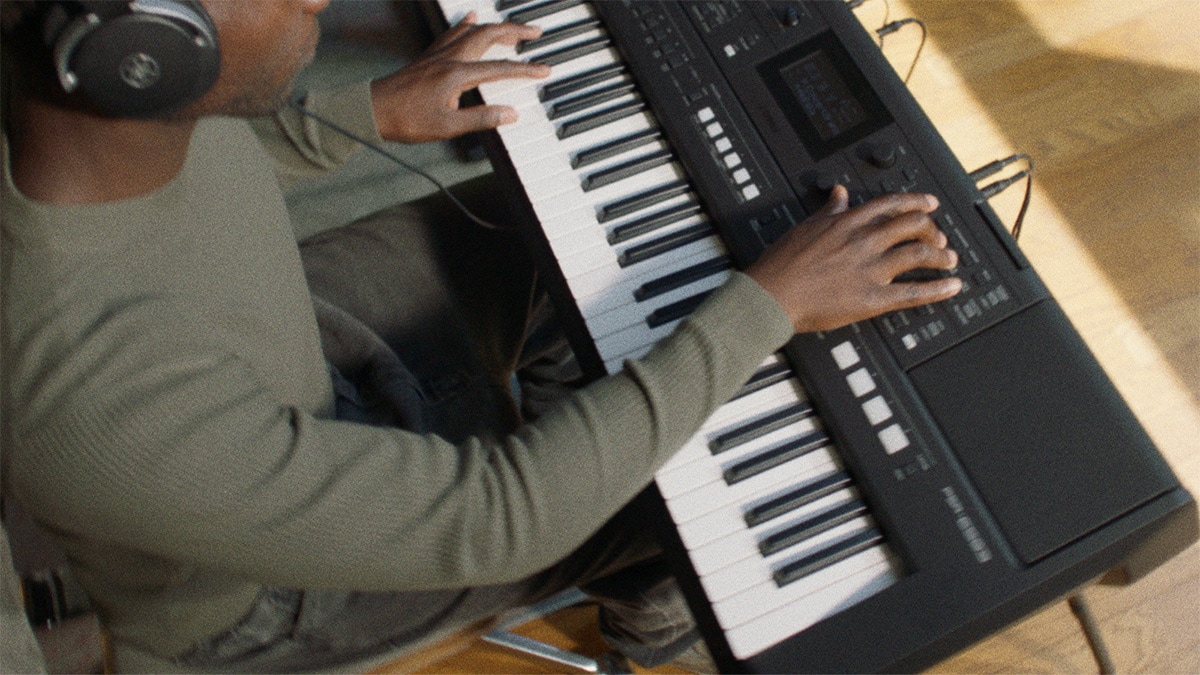 Personne jouant sur un clavier portable Yamaha PSR-E483 avec un casque audio