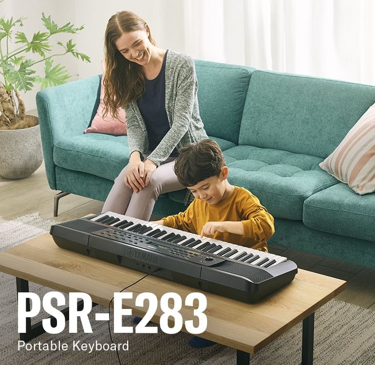 Parent and child happily playing the PSR-E283 on the table