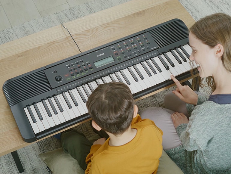 Parent and child happily playing the PSR-E283 side by side