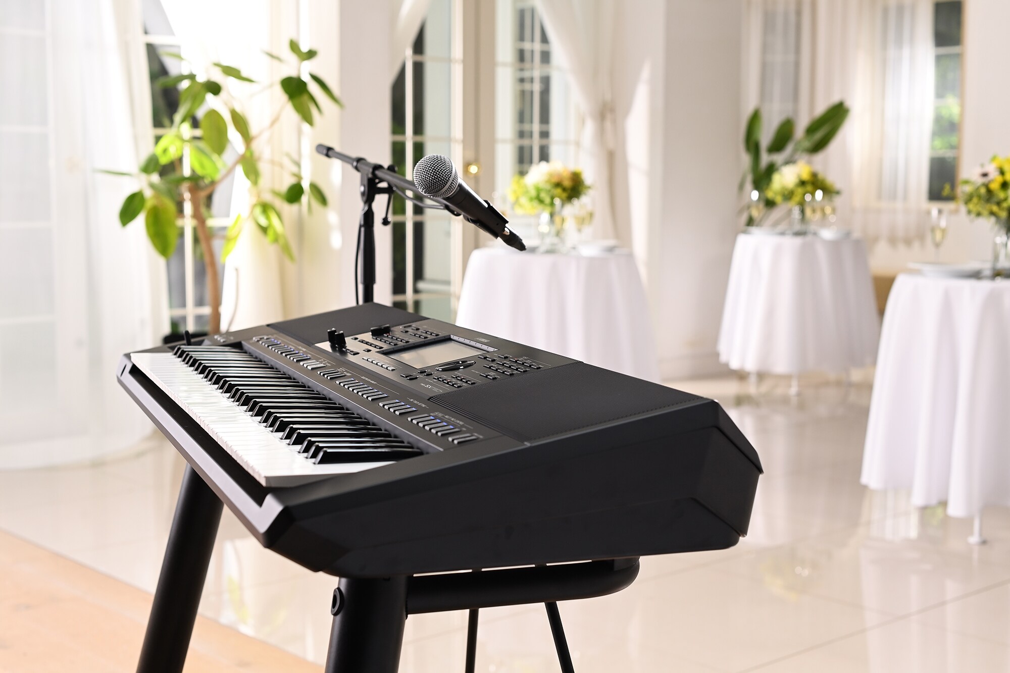 Clavier arrangeur Yamaha PSR-SX720+ avec un pied de micro dans un lieu de fête