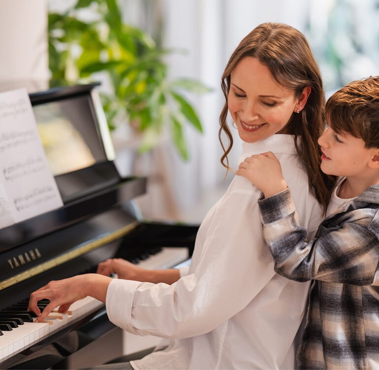 Une mère et sa fille prennent plaisir à jouer sur le piano droit de la série B