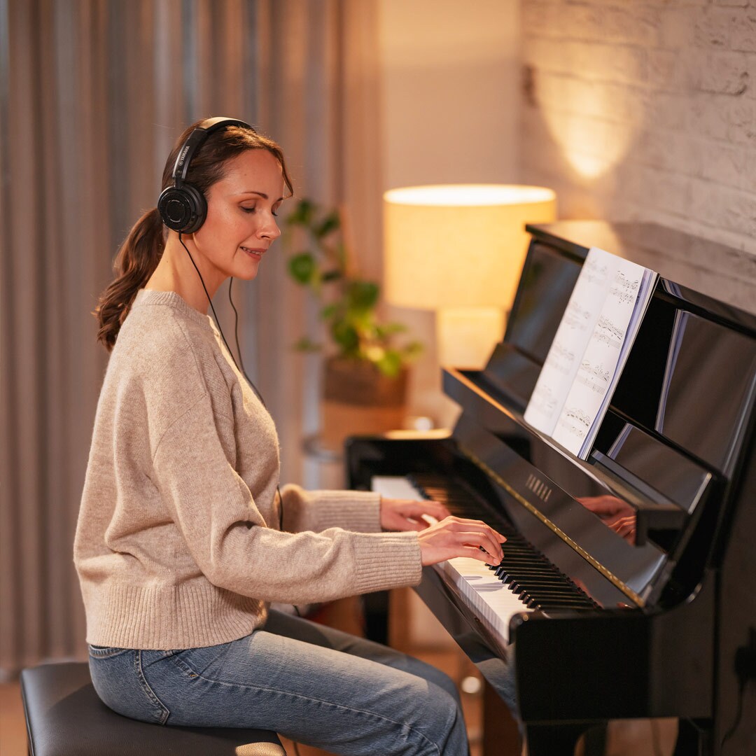 Une femme prend plaisir à jouer du piano avec un casque