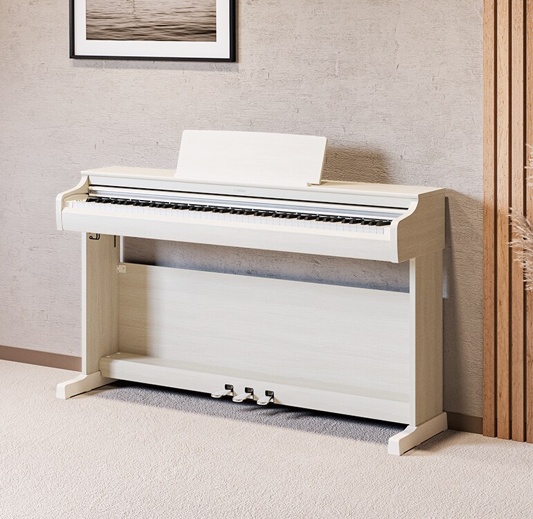 Un salon accueillant un piano ARIUS bouleau blanc avec des plantes d'intérieur et un canapé, s'intégrant harmonieusement à la décoration.
