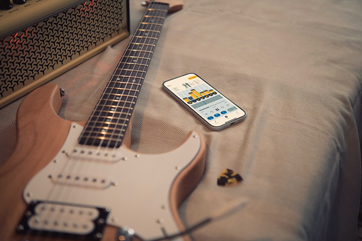 L'application d'entraînement musical Extrack à proximité d'une guitare électrique et d'un amplificateur